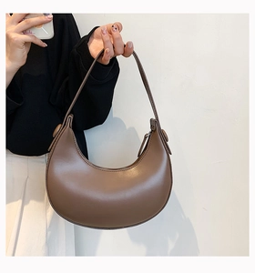 Detail of a vintage dark brown crescent shoulder bag in smooth leather with zipper