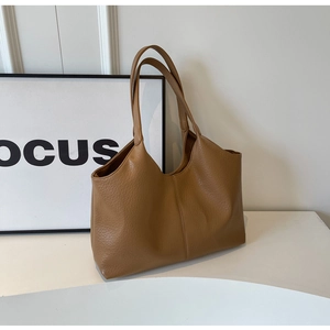 Close-up of the brown tote bag featuring premium pebble grain texture and stitching details