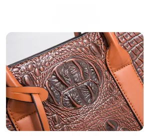 Détail de la texture cuir gaufré crocodile marron et finition des bords sur le sac à main