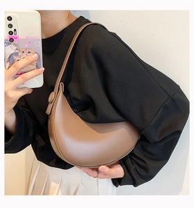 Brown semi-circle PU leather shoulder bag worn by model for a minimalist daily style