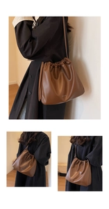 Macro detail of brown soft faux leather hobo bag with drawstring closure and fine pleats
