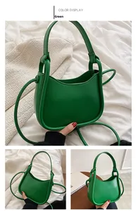 Detailed close-up of a green crescent PU leather handbag with cylindrical piping details