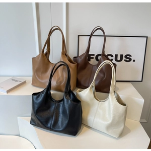 Detailed display of four large soft leather tote bags in brown, tan, black, and white