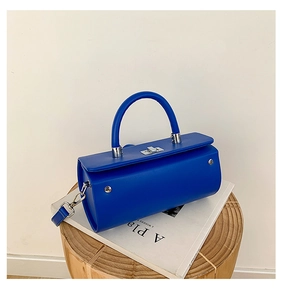 Détail du sac à main cylindrique bleu avec fermoir rotatif argenté et cuir lisse