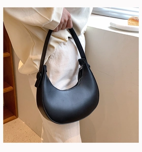 Detail of the black crescent shoulder bag featuring smooth leather and adjustable buckle
