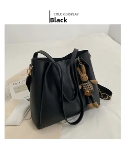 Detail of black large capacity tote bag with detachable patterned strap and rabbit charm