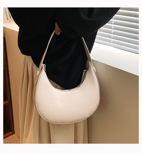 Chic cream crescent shoulder bag shown on model for a trendy minimalist summer aesthetic