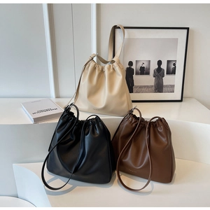 Minimalist soft leather bucket bags in cream white, black, and brown with drawstring details