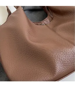 Close-up of soft brown lychee grain leather on a hobo tote bag showing rich texture
