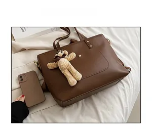 Deep brown tote bag with textured finish featuring a cute beige knit bear charm