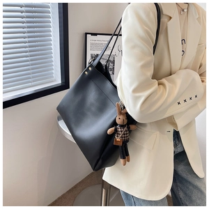 Detail of large black tote bag with gold studs and a cute houndstooth rabbit charm