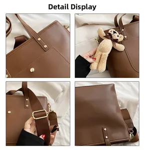 Detail view of brown faux leather tote with golden hardware and bear charm