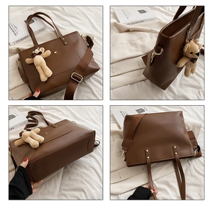 Detail view of large brown tote bag with adjustable strap and cute bear charm