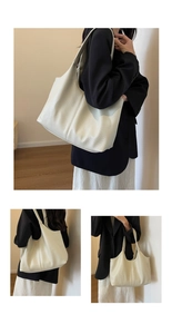 Macro detail of creamy white lychee grain leather tote bag with long shoulder strap