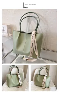 Detail view of a light green tote bag featuring vertical stitching and a silk scarf accent