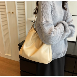Detail of soft cream drawstring shoulder bag with pleated closure and miao & she branding