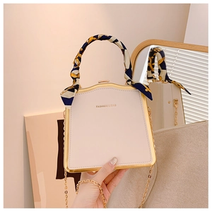 Dettaglio borsa a scatola alla moda con manico in foulard e cornice in oro rosa