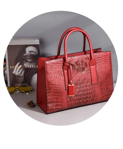 Détail macro du sac à main rouge en cuir gaufré crocodile avec motifs texturés uniques