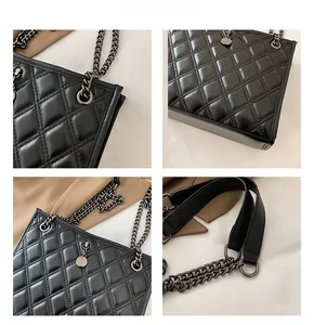 Detail view of black quilted leather texture and metal chain strap on shoulder bag