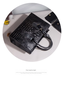Détail du sac à main noir motif crocodile avec portefeuille assorti en coffret