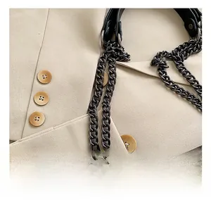 Close-up of premium black leather quilted bag featuring a thick dark grey metal chain strap