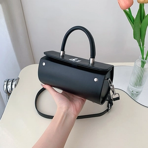 Sac cylindrique noir minimaliste avec détails métalliques argentés et bandoulière amovible