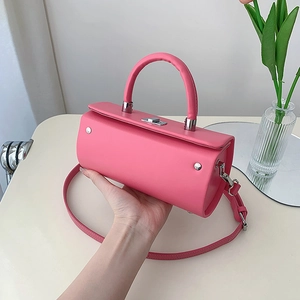 Sac à main cylindrique rose barbie avec boucles argentées et bandoulière réglable