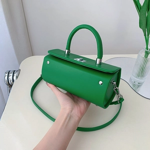 Sac à main cylindrique en cuir vert élégant avec fermoir rotatif argenté et poignée