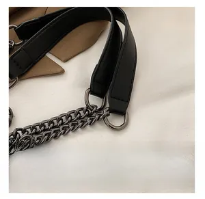 Detail shot of black quilted bag strap with premium dark gray metal chain links