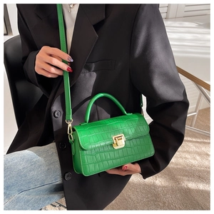Detail showing bright green crocodile pattern leather bag with gold metal lock
