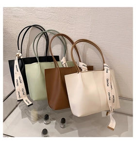 Group display of large capacity tote bags in four colors with decorative letter ribbons