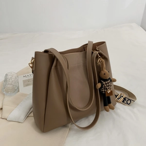 Brown large capacity leather tote bag with a cute rabbit charm and wide shoulder strap