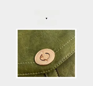 Detail of vintage green leather crossbody bag with a high-quality golden oval twist lock
