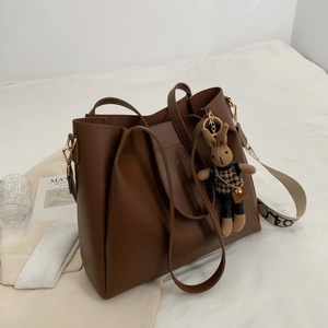 Minimalist large brown tote bag with stylish wide strap and cute rabbit pendant decoration