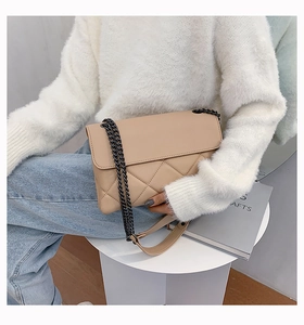 Close-up of quilted apricot chain bag with metal strap and premium faux leather texture