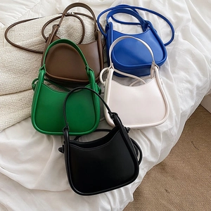 Minimalist half-moon handbags in five colors shown on white linen fabric for daily fashion