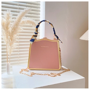 Borsa rosa con manico decorato da foulard di seta e tracolla a catena dorata elegante
