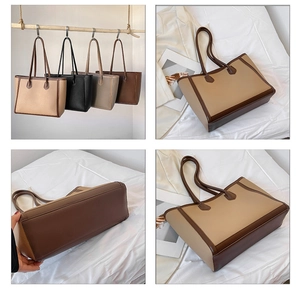Detail of large tote bag showing litchi grain leather texture and double handles