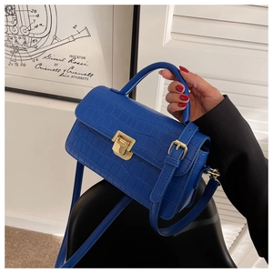 Close-up of royal blue crocodile embossed PU leather handbag with a gold metal lock
