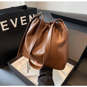 Detail of caramel brown leather bucket bag in a luxury gift box with adjustable straps