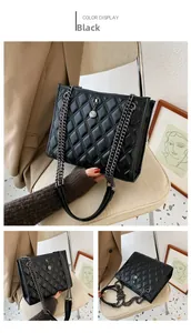 Detail view of black quilted shoulder bag with chic silver chain and metal charm pendant