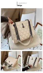 Detail view of beige quilted shoulder bag with black metal chain and round pendant charm