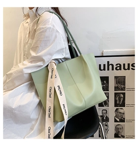 Light green large capacity tote bag with printed silk ribbon detail on model