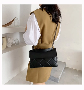 Classic black quilted chain shoulder bag shown from a side perspective on a model