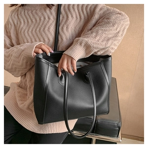 Close-up of black lychee grain leather tote bag showing large capacity and texture