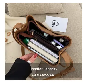 Detail view of large capacity brown leather bucket bag with zippered interior compartments