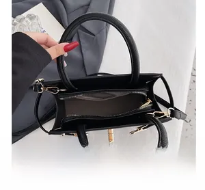 Detail view of the black pebbled leather tote interior with golden zippers and compartments