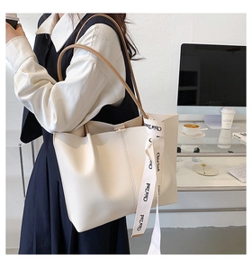 Detailed shoulder view of a large cream tote bag with ribbon detail for office commute