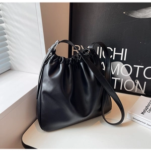 Detailed view of the black pleated soft leather shoulder bag with adjustable thin strap