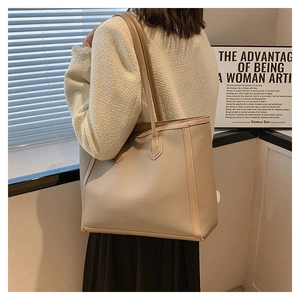 Detail of beige pebbled leather tote bag showing spacious capacity and shoulder straps